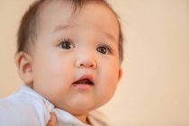 Primer plano vista de adorable asiático bebé sobre rosa fondo - foto de stock