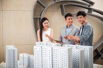 Professional smiling young architects discussing project in office — Stock Photo
