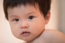 Close-up portrait of adorable asian baby looking at camera — Stock Photo
