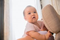 Обрезанный снимок родителя, несущего очаровательного азиатского младенца дома — стоковое фото