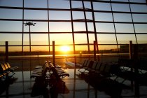 Vue aérienne par fenêtre depuis le salon vide de l'aéroport pendant le coucher du soleil — Photo de stock