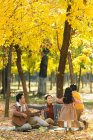 Feliz jovem asiático família com duas crianças passar tempo juntos durante piquenique no parque — Fotografia de Stock