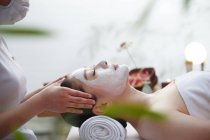Giovane donna asiatica che riceve massaggio alla testa al salone spa — Foto stock