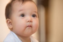Крупним планом вигляд чарівного азіатського немовляти дивиться вдома — стокове фото