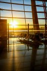 Всередині порожнього сучасного лаунжу аеропорту під час заходу сонця — стокове фото