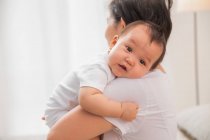 Plan recadré de parent portant bébé asiatique adorable à la maison — Photo de stock