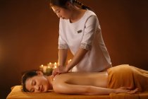 Giovane donna asiatica che riceve massaggio corpo al salone spa — Foto stock