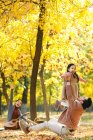 Happy asian father lifting daughter in autumnal park — Stock Photo