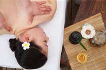Вид зверху на молоду азіатку, що отримує масаж тіла в спа-салоні — стокове фото