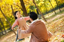 Счастливая дочь и отец собираются обниматься в осеннем парке — стоковое фото