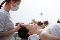Молодая азиатка получает массаж головы в спа-салоне — стоковое фото