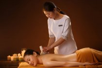 Joven asiático mujer recibiendo cuerpo masaje en spa salon - foto de stock