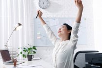 Attractive asian businesswoman stretching in light office — Stock Photo