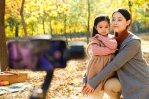 Feliz asiático pai tomando foto de filha e esposa com smartphone no parque outonal — Fotografia de Stock