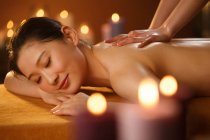 Giovane donna asiatica che riceve massaggio corpo al salone spa — Foto stock