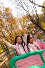 Happy boy and girls playing together on roller coaster in park — Stock Photo