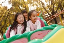 Щасливий хлопчик і дівчата грають разом на роликових гірках в парку — стокове фото