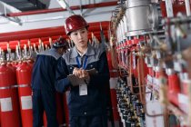 Engenheiros profissionais masculinos e femininos em chapéus duros que trabalham na inspeção da sala de controle de incêndio da fábrica — Fotografia de Stock
