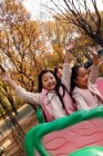 Feliz niño y niñas jugando juntos en montaña rusa en el parque - foto de stock