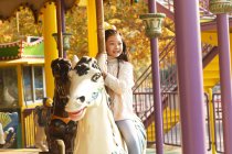 Entzückend glückliches kleines Mädchen spielt mit Karussell — Stockfoto