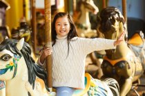 Очаровательная счастливая девочка, играющая с каруселью — стоковое фото