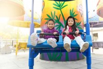 Meninas felizes jogando juntos na montanha-russa no parque — Fotografia de Stock