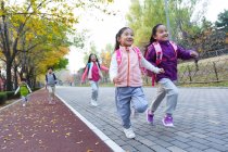 Fünf entzückende asiatische Kinder laufen auf der Straße im herbstlichen Park — Stockfoto