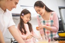 Щаслива китайська сім'я з однією дитиною, що готує разом на кухні — стокове фото