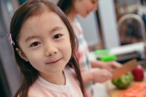 Крупним планом красива азіатська дитина готує з матір'ю на кухні — стокове фото