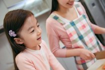 Abgeschnittene Aufnahme von entzückenden asiatischen Kind Kochen mit Mutter in der Küche — Stockfoto