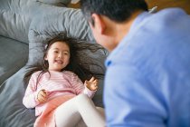 Glücklich asiatische Vater und Niedlich kleine Tochter spielen und Spaß zusammen auf couch — Stockfoto