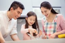 Happy asian family with one child cooking together in kitchen — Stock Photo