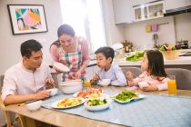 Happy asian family with two kids having dinner together at home — Stock Photo