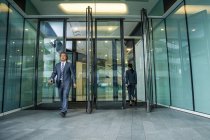 Asian business people walking in modern business center — Stock Photo