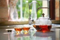 Vue rapprochée de l'ensemble thé en verre avec bouilloire et tasses en verre sur la table — Photo de stock