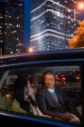 Happy asian couple riding in car and looking at each other at evening — Stock Photo