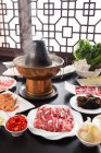 Медь горячая кастрюля, мясо, овощи и морепродукты на столе, тертый концепции блюдо — стоковое фото
