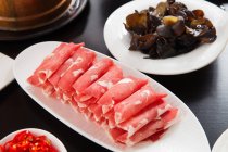 Close-up view of sliced meat and copper hot pot, chafing dish concept — Stock Photo