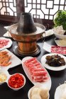 Nahaufnahme von geschnittenem Fleisch, Garnelen und Gemüse mit Kupfer Hot Pot, Scheuern Gericht Konzept — Stockfoto