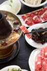 Nahaufnahme von Essstäbchen mit Fleisch über Kupfer-Hotpot, Scheuern Teller-Konzept — Stockfoto