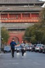 Pleine longueur vue de sourire jeune asiatique joggers formation ensemble sur rue — Photo de stock