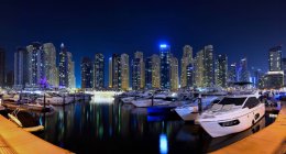 Incredibile famoso porto turistico di Dubai con yacht e grattacieli riflessi in acqua di notte — Foto stock