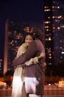 Щаслива азіатська пара обіймає на вулиці ввечері — стокове фото