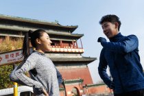 Basso angolo vista di spoty giovane asiatico coppia parlare e sorridente ogni altro durante allenamento su strada — Foto stock