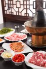 Close-up view of meat, vegetables and seafood with copper hot pot, chafing dish concept — Stock Photo