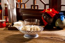 Крупный план традиционных китайских пельменей в миске на столе — стоковое фото