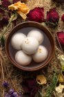 Draufsicht auf klebrige Reisbällchen in Schüssel und trockenen Blumen — Stockfoto