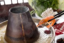 Vista close-up de panela de cobre quente e pauzinhos com camarão, conceito prato chafing — Fotografia de Stock