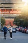 Pleine longueur vue de sourire jeune asiatique joggers formation ensemble sur rue — Photo de stock