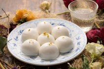 Close-up view of glutinous rice balls on plate and dry flowers — Stock Photo